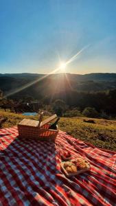 a picnic blanket with a basket on top of a hill at Cabanas Recanto do Rancho - Rancho Queimado in Rancho Queimado