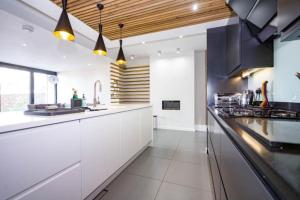 a kitchen with white cabinets and a long counter at George24 - spectacular, 5 minutes to the beach in Newquay