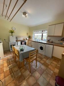 a kitchen with a table and some chairs and a table and a kitchen at The Annexe Cottage at Newhouse Farm in Lanark