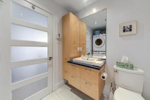 a bathroom with a toilet and a sink and a washing machine at Les Immeubles Charlevoix - Le 760206 in Quebec City
