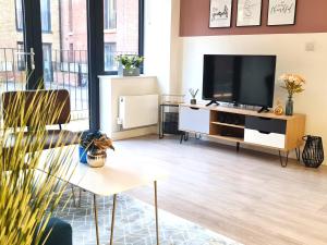 a living room with a flat screen tv on a cabinet at Elegant 2BR in Bedford, Parking, Free WiFi, Gym and Cinema room in Bedford