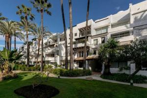 un gran edificio blanco con palmeras y un patio en Super Stylish apartment in La Alcazaba - RDR172, en Marbella