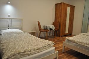 1 dormitorio con 2 camas, mesa y silla en Apartament u Zięby, en Duszniki-Zdrój