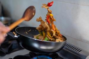 a stir fry in a pan on a stove at Green Resort Suncuius in Şuncuiuş