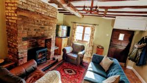 - un salon avec un canapé et une cheminée dans l'établissement Martha's Cottage, à Ironbridge