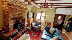 a living room with a couch and a fireplace at Martha's Cottage in Ironbridge