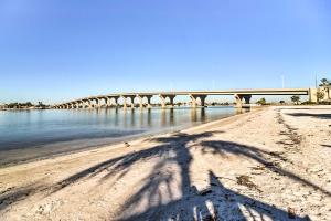 a shadow of a person on the beach with a bridge in the background at St Pete Condo with Private Lanai and Community Pool! in St Petersburg