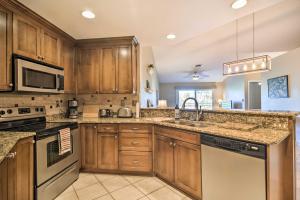a kitchen with wooden cabinets and a sink at St Pete Condo with Private Lanai and Community Pool! in St Petersburg