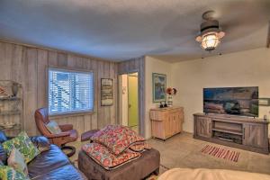 uma sala de estar com um sofá e uma televisão em NSB Townhome with Pool and Private Beach Access! em New Smyrna Beach