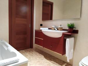 uma casa de banho com um lavatório branco e um espelho. em Sunset View Treviso Apartment em Treviso