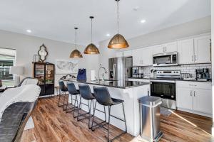 una cucina con mobili bianchi e un bar con sgabelli di SunDaze a Branson