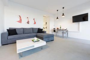 ein Wohnzimmer mit einem blauen Sofa und einem Tisch in der Unterkunft "M n' F" apartment in Athen