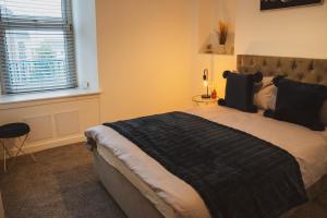 Un dormitorio con una cama grande y una ventana en 1 bedroom flat with easy parking/public transport, en Dundee