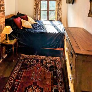 a bedroom with a bed with a rug and a window at Martha's Cottage in Ironbridge