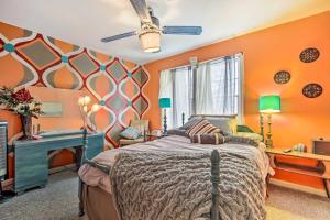 1 dormitorio con paredes de color naranja, 1 cama y escritorio en Artsy Getaway about 8 Miles to Downtown Kansas City! en Independence