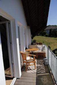 eine Terrasse mit einem Tisch und einem Sofa auf dem Balkon in der Unterkunft Ferienwohnung mit Charme in Bad Salzschlirf