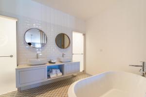 a bathroom with two sinks and a tub and a mirror at LP Heritage Apartments in Braga