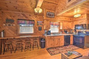 a kitchen with wooden cabinetry and a counter with stools at Helen Cabin with Deck and Hot Tub Less Than half Mi to Main St in Helen