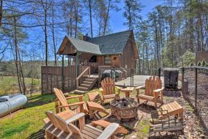 a backyard with chairs and a fire pit and a cabin at Helen Cabin with Deck and Hot Tub Less Than half Mi to Main St in Helen