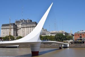 un puente blanco en el agua con edificios en el fondo en Arte y Música en Buenos Aires
