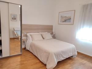 um quarto com uma grande cama branca e um espelho em LOFT MONTECERRAO H GARAJE Y WiFi GRATIS em Oviedo