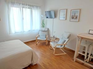 a bedroom with two chairs and a bed and a desk at LOFT MONTECERRAO H GARAJE Y WiFi GRATIS in Oviedo