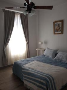 1 dormitorio con 1 cama y ventilador de techo en Arte y Música en Buenos Aires