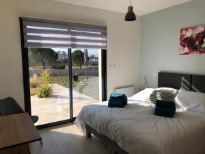 une chambre avec un lit et une porte coulissante en verre dans l'établissement La Petite Reine, à Villes-sur-Auzon