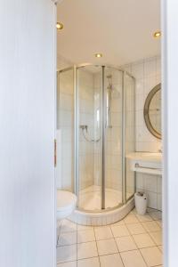 a bathroom with a shower and a toilet and a sink at Gästehaus Chalet-Perle in Bad Füssing