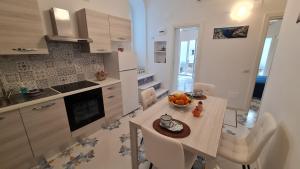 a kitchen with a table with a bowl of fruit on it at Casa Piccina in Praiano