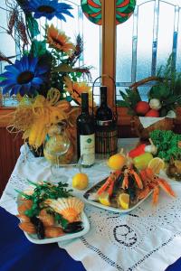 a table with two plates of food and bottles of wine at Hotel Stanger in Lovran
