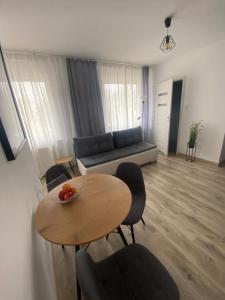 a living room with a table and chairs and a couch at Apartamenty Zatorze in Leszno