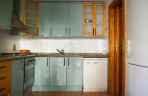 a kitchen with blue cabinets and a sink and a dishwasher at N28 in Xàtiva