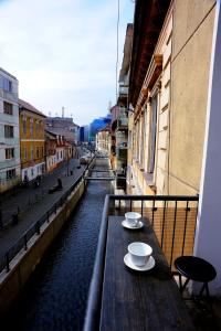 a table on a balcony with a view of a canal at Apartament Downtown Cluj-Napoca in Cluj-Napoca