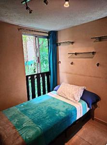 Dormitorio pequeño con cama y ventana en México Querido Basílica Gpe-Aeropuerto, en Ciudad de México