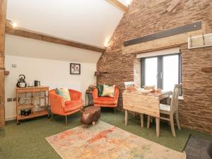 a living room with a table and chairs and a brick wall at Palace Studio in Hereford