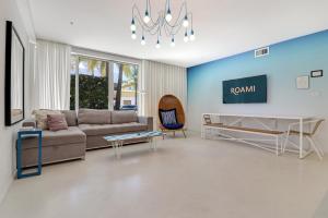 a living room with a couch and a tv at Roami at 250 Collins in Miami Beach
