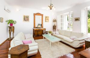 una sala de estar con 2 sofás blancos y una mesa. en Villa Marini Dvori - with free parking, en Dubrovnik