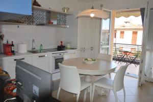 a kitchen with a table and chairs and a television at Salice ottimo trilocale con terrazza pranzabile in Marina di Castagneto Carducci