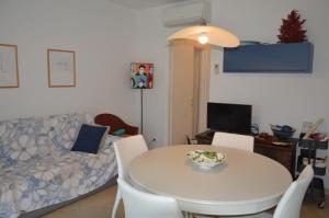 a living room with a white table and a couch at Salice ottimo trilocale con terrazza pranzabile in Marina di Castagneto Carducci