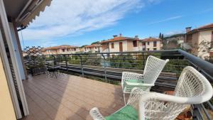 a balcony with two chairs and a view of some buildings at Salice ottimo trilocale con terrazza pranzabile in Marina di Castagneto Carducci