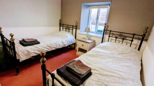 En eller flere senge i et værelse på Martha's Cottage