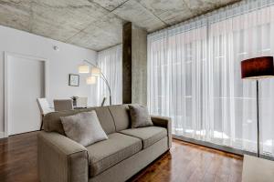 uma sala de estar com um sofá e uma grande janela em Les Immeubles Charlevoix - Le 760207 em Cidade de Quebec