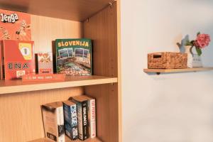 a book shelf with books and a box on it at DREAMLAND BLED Apartments in Bled