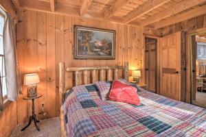 Un dormitorio con una cama con una almohada roja. en Rustic Madison Treehouse Cabin with Game Room!, en Madison