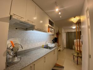 une cuisine avec des placards blancs et un comptoir dans l'établissement Affordable Staycation at COOL SUITES by SMDC Wind Residences, à Tagaytay