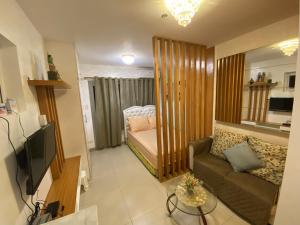 un piccolo soggiorno con divano e letto di Affordable Staycation at COOL SUITES by SMDC Wind Residences a Tagaytay