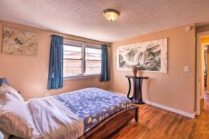 1 dormitorio con 1 cama con cortinas azules y ventana en Cozy Colorado Springs Home Near Garden of the Gods, en Colorado Springs