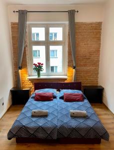 a bedroom with a bed with two pillows and a window at Topolove Rooms & Apartments in Krakow