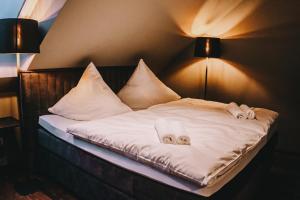 a bed with white sheets and pillows on it at LA vie Hotel Landshut in Landshut